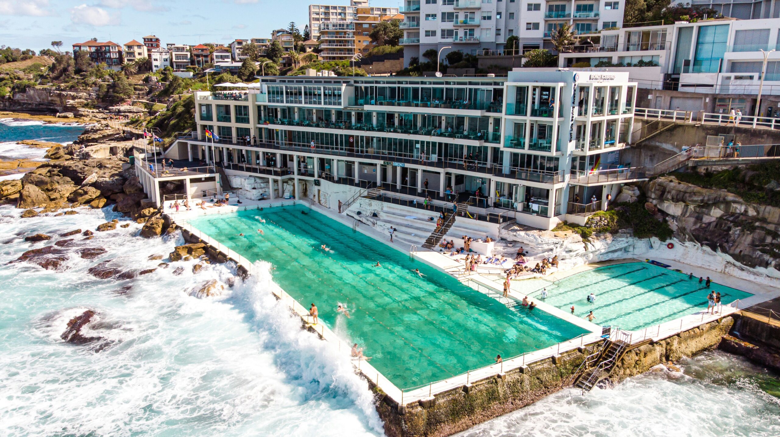 a green swimming pool in front of a big white building