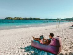 The Rise of Digital Nomad Villages in Remote Locations guy working from the beach