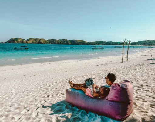 The Rise of Digital Nomad Villages in Remote Locations guy working from the beach