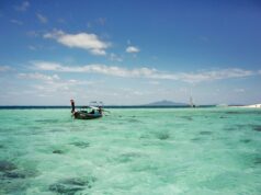 Island Hopping in Thailand old wooden longtail boat on crystal clear water