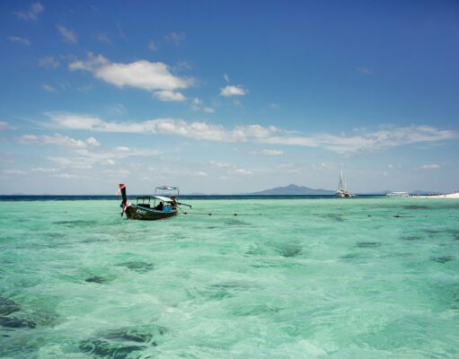 Island Hopping in Thailand old wooden longtail boat on crystal clear water