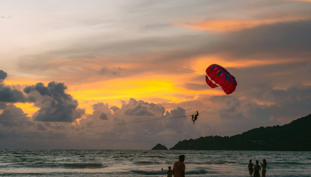 paragliding over a sandy beach