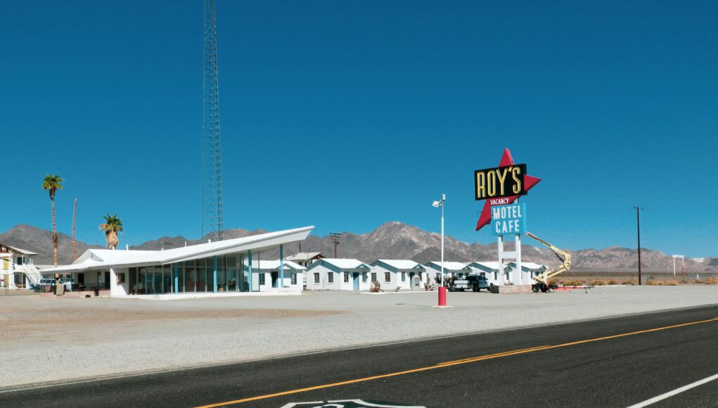 an empty road with a diner next to it