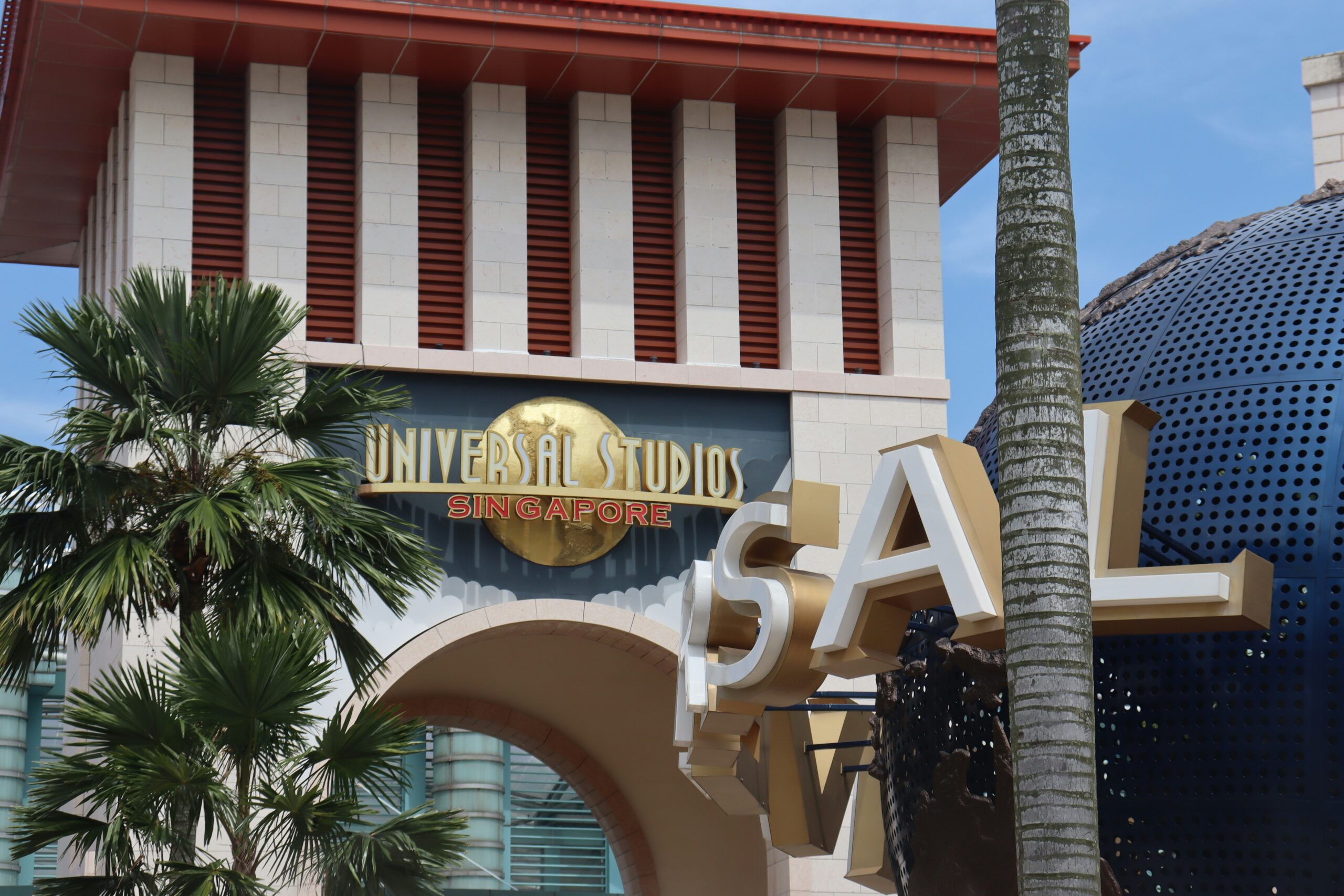 A planet sign next to palm trees