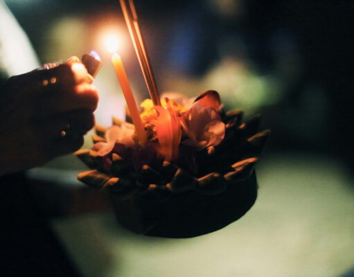 Celebrating Loy Krathong in November: Thailand’s Festival of Lights a candle being lit