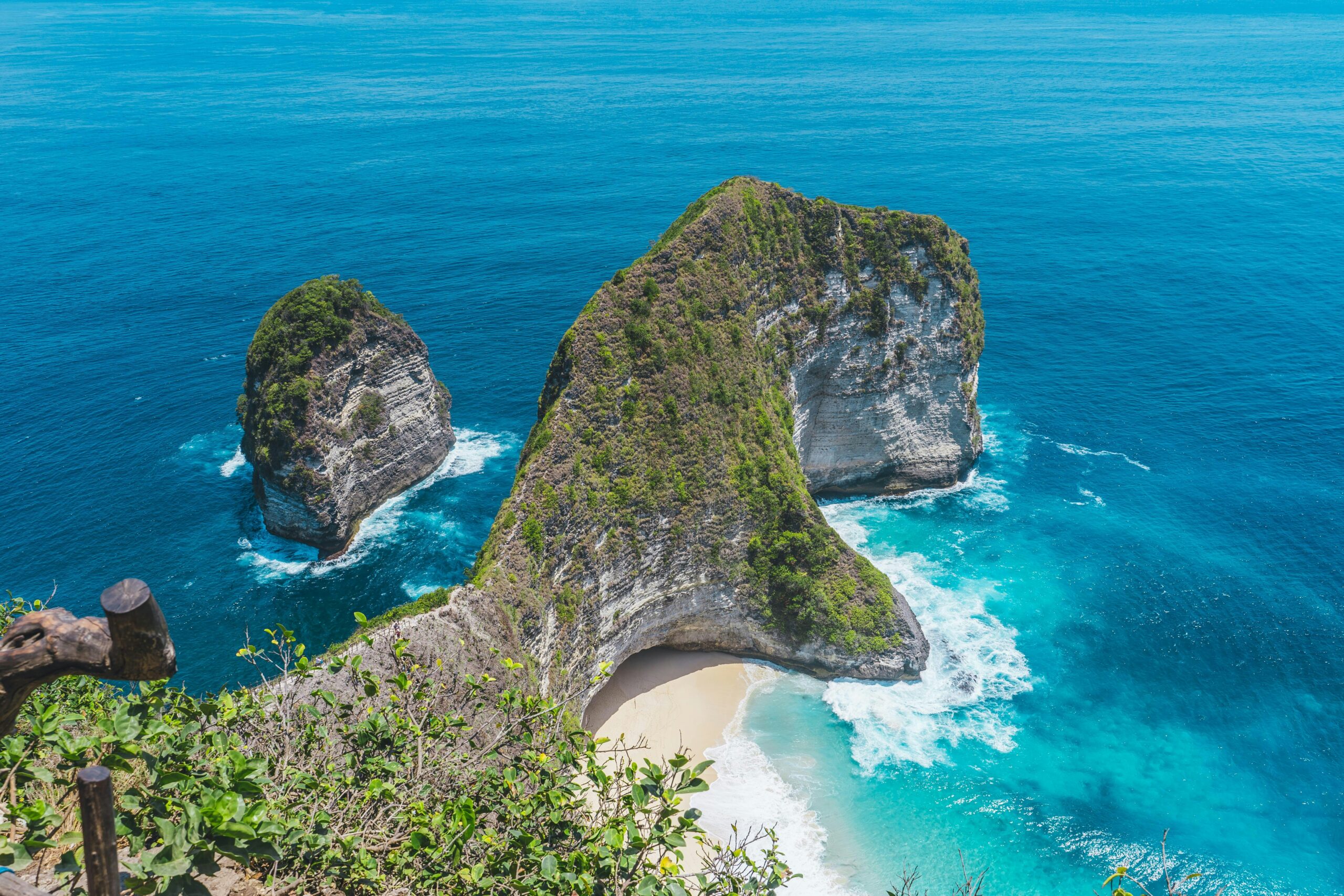 a cliff side and a white sand beach