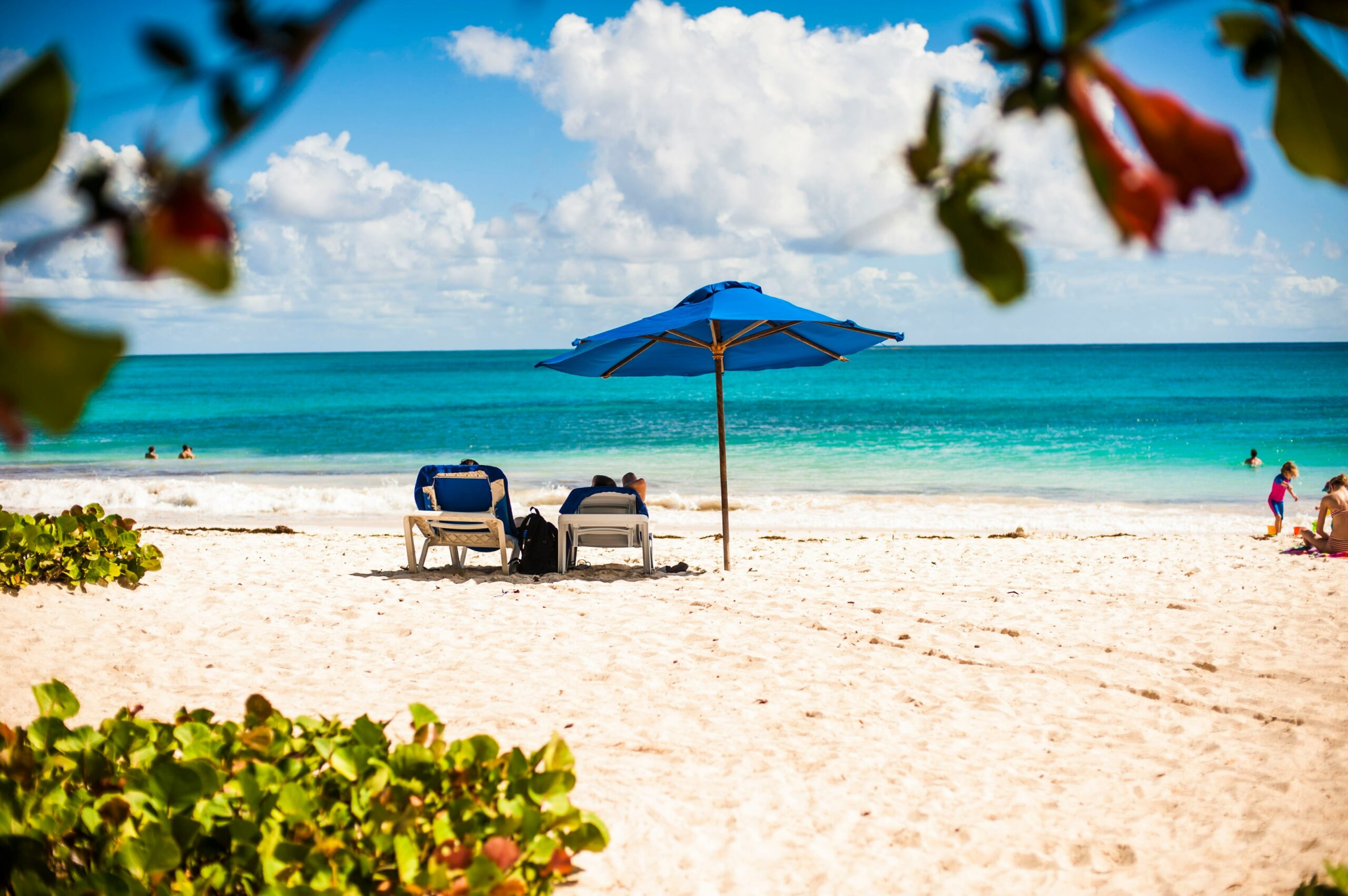 a blue umbrella on a white sand beach 