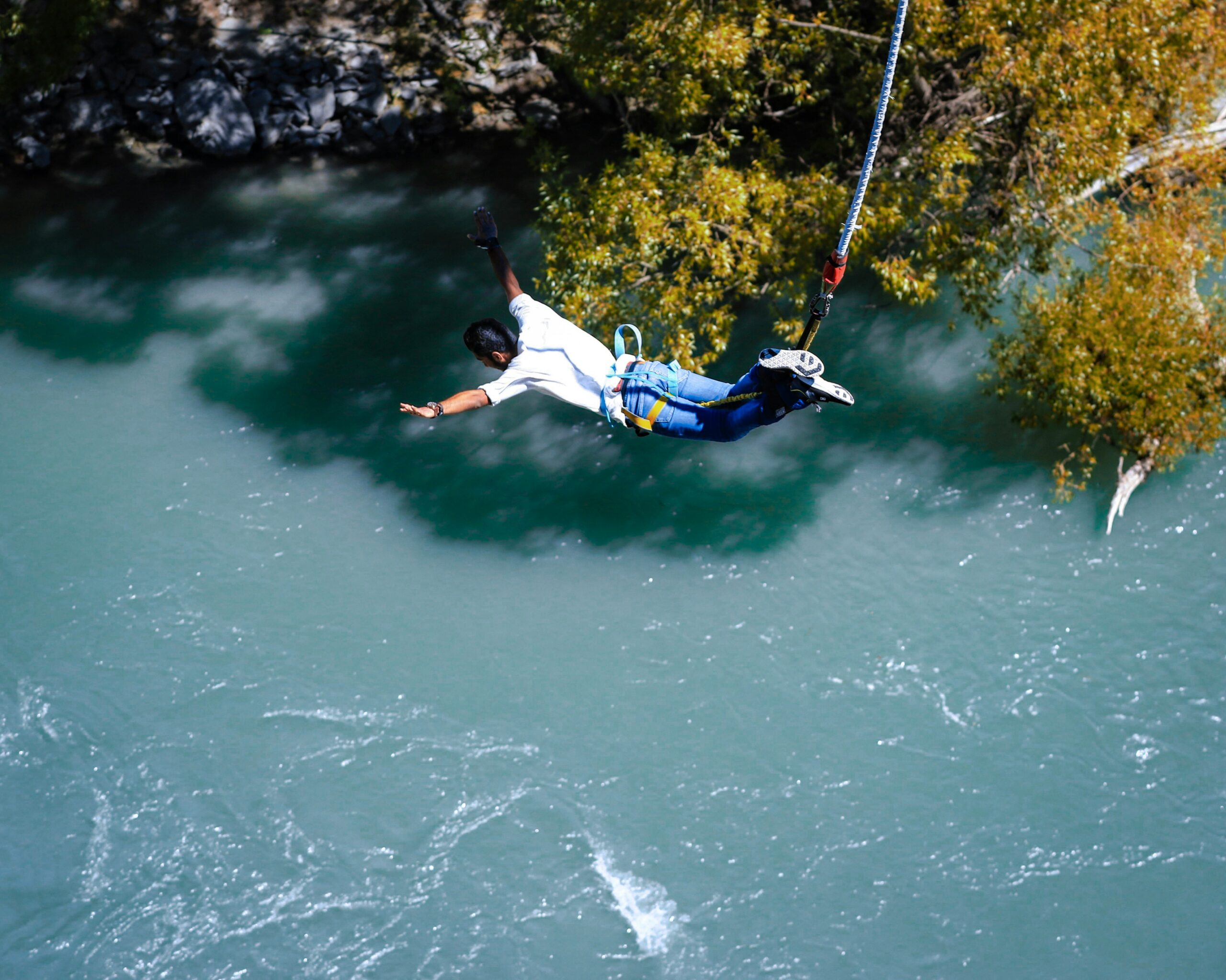 a guy jumping towards a river