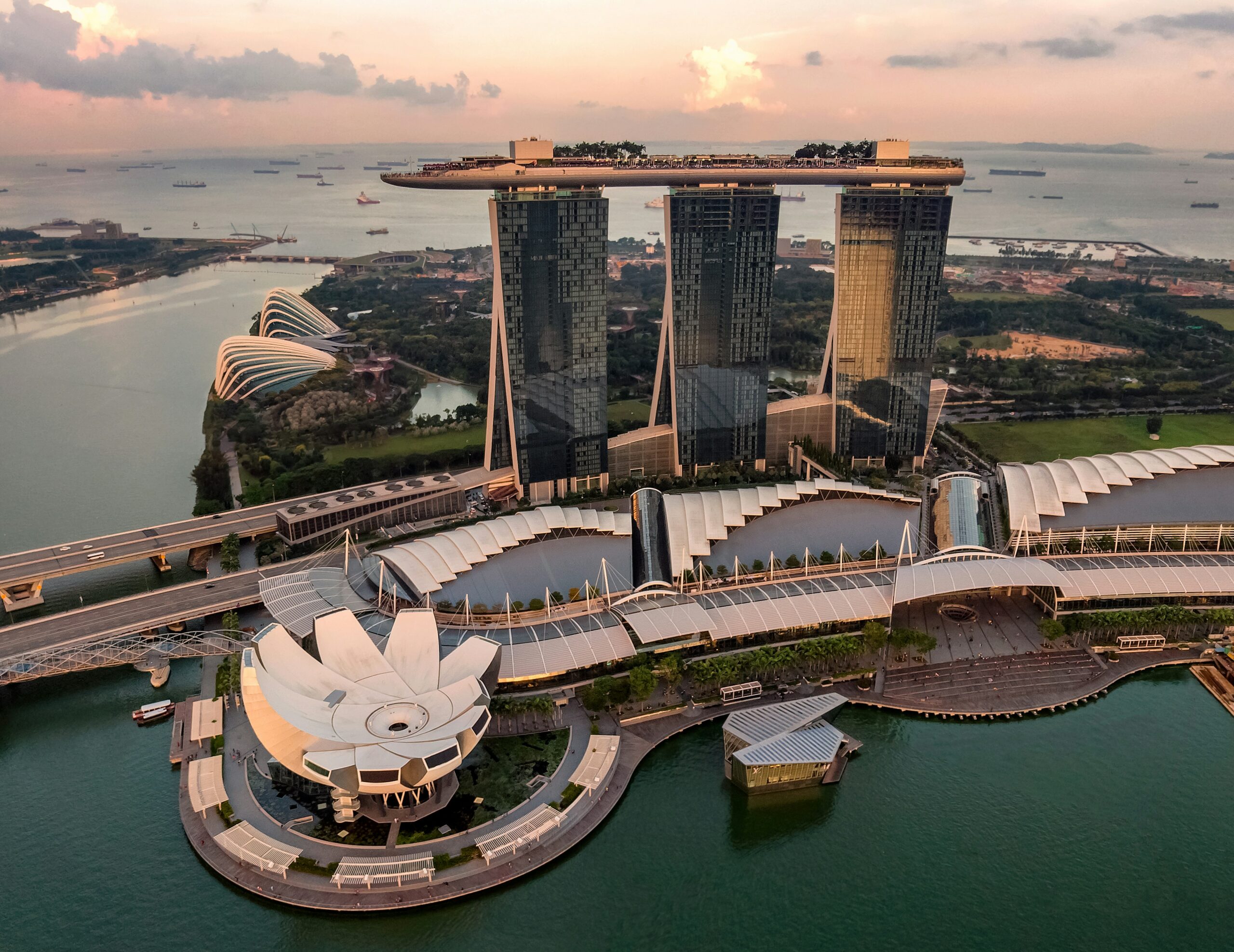 three tall buildings with a boat shaped building on top