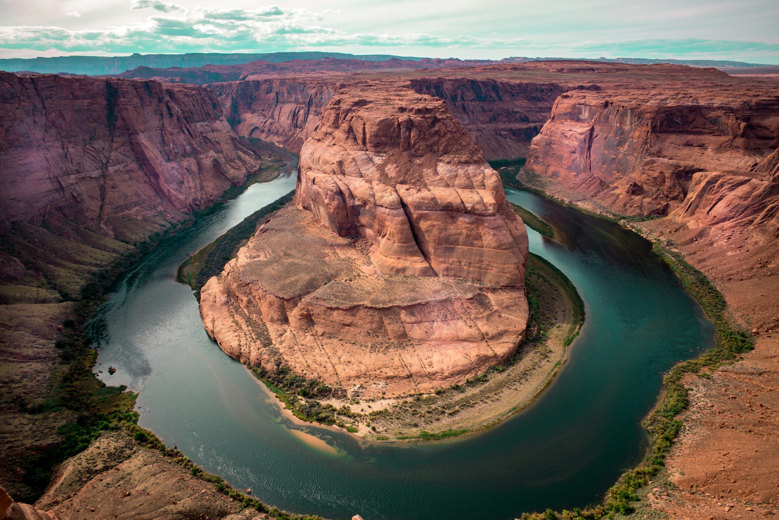 a green river going going around a cliff