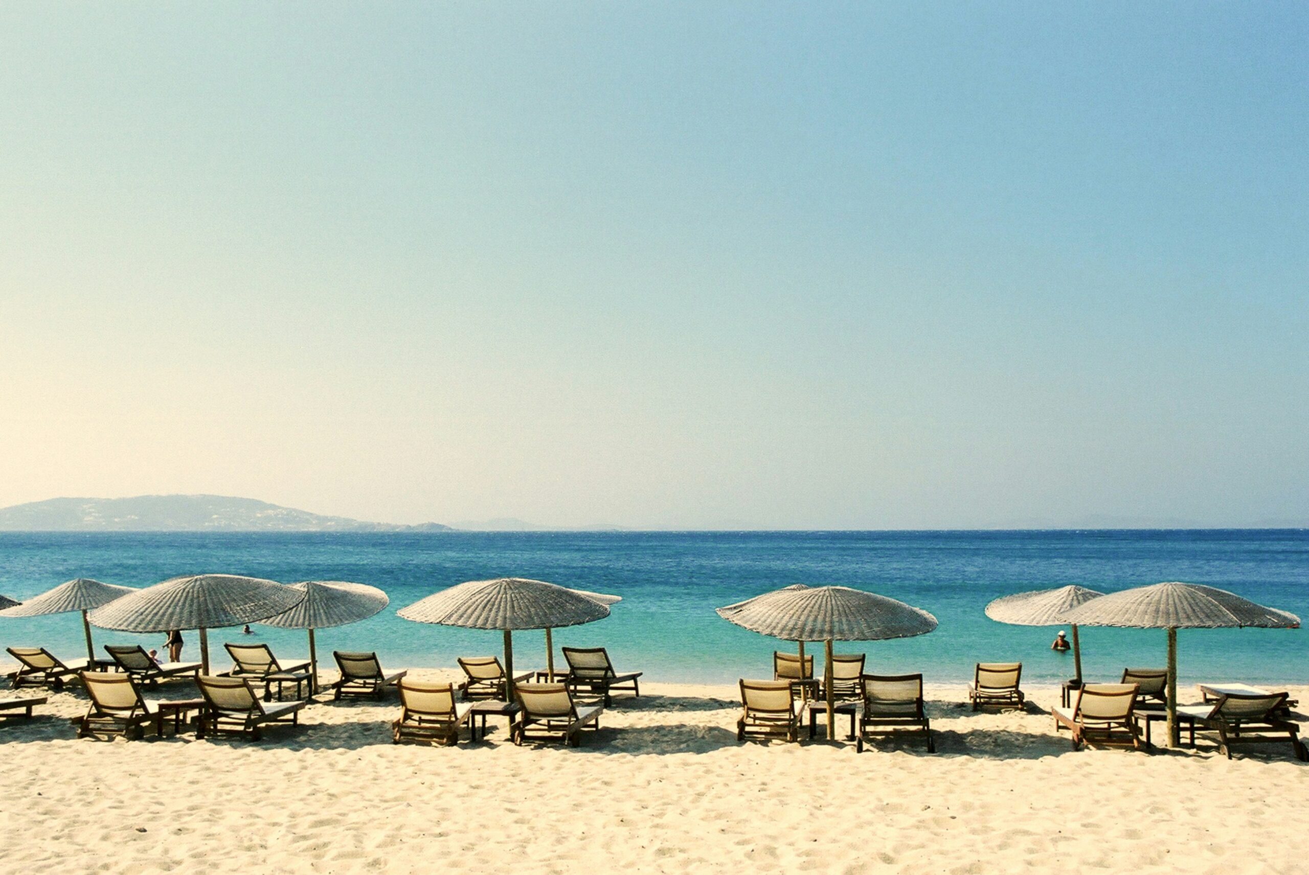 a bunch of sun umbrellas on a beach