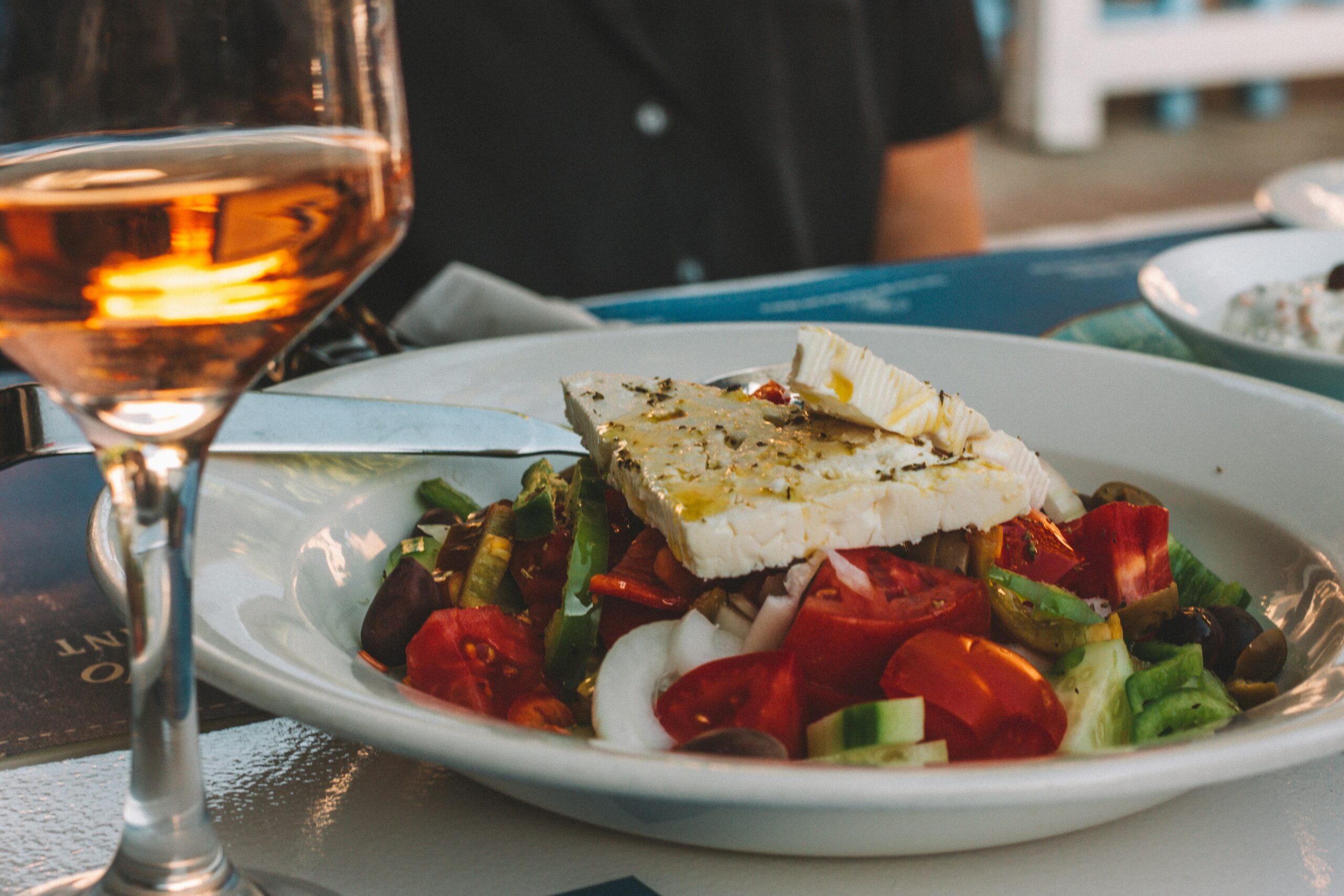 a plate of salad and a glass of wine