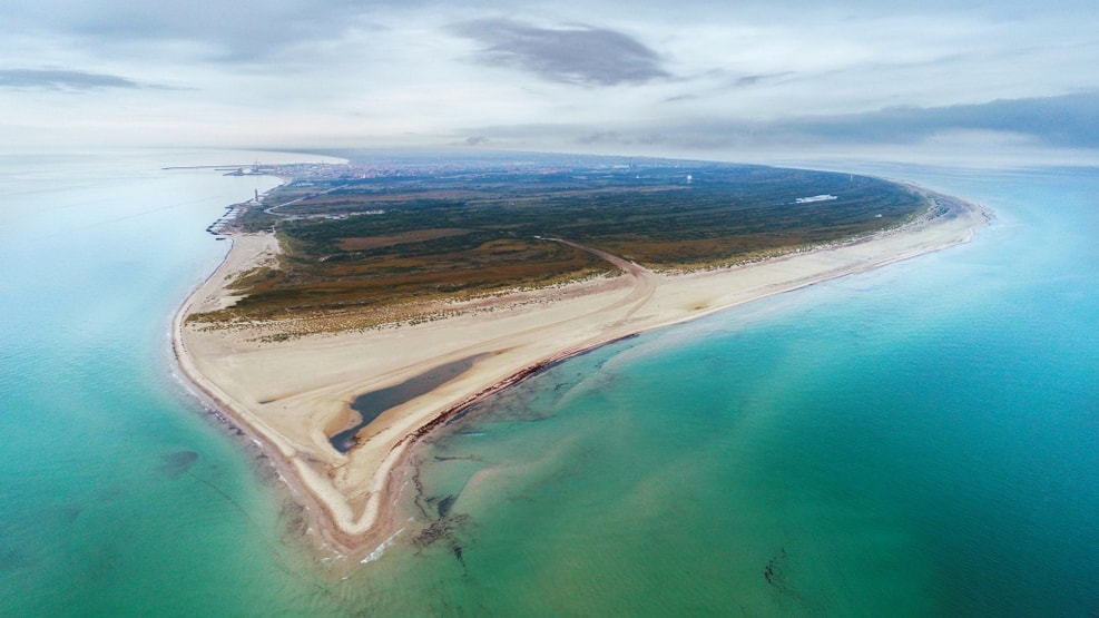 a sandy beach with waves from two sides