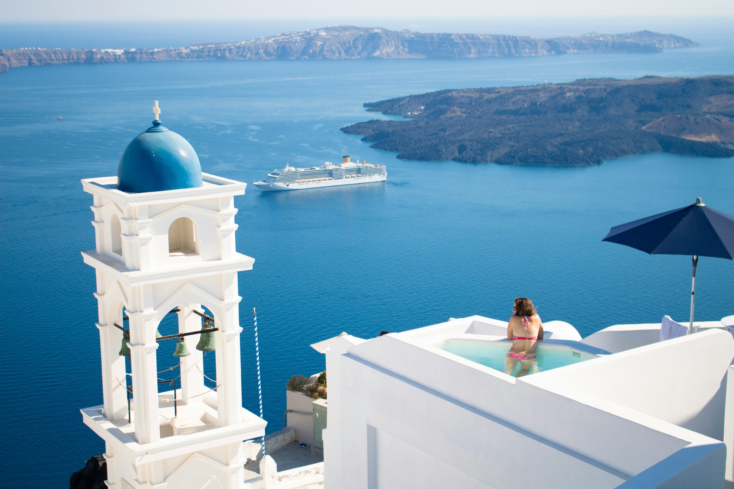 a woman in a swimming pool overlooking a ferry