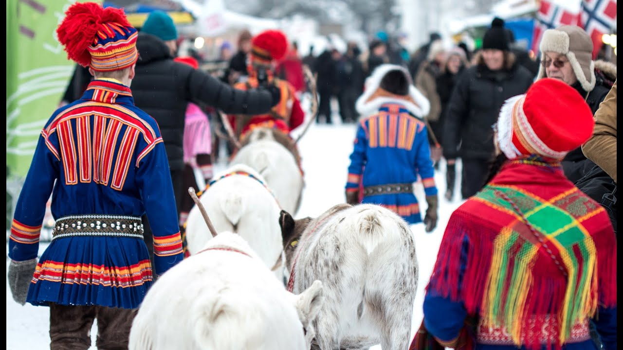 reindeers at a winter market being pulled by a guy in blue