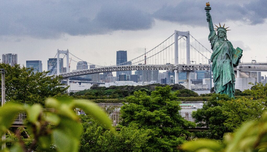 A statue in front of a big bridge
