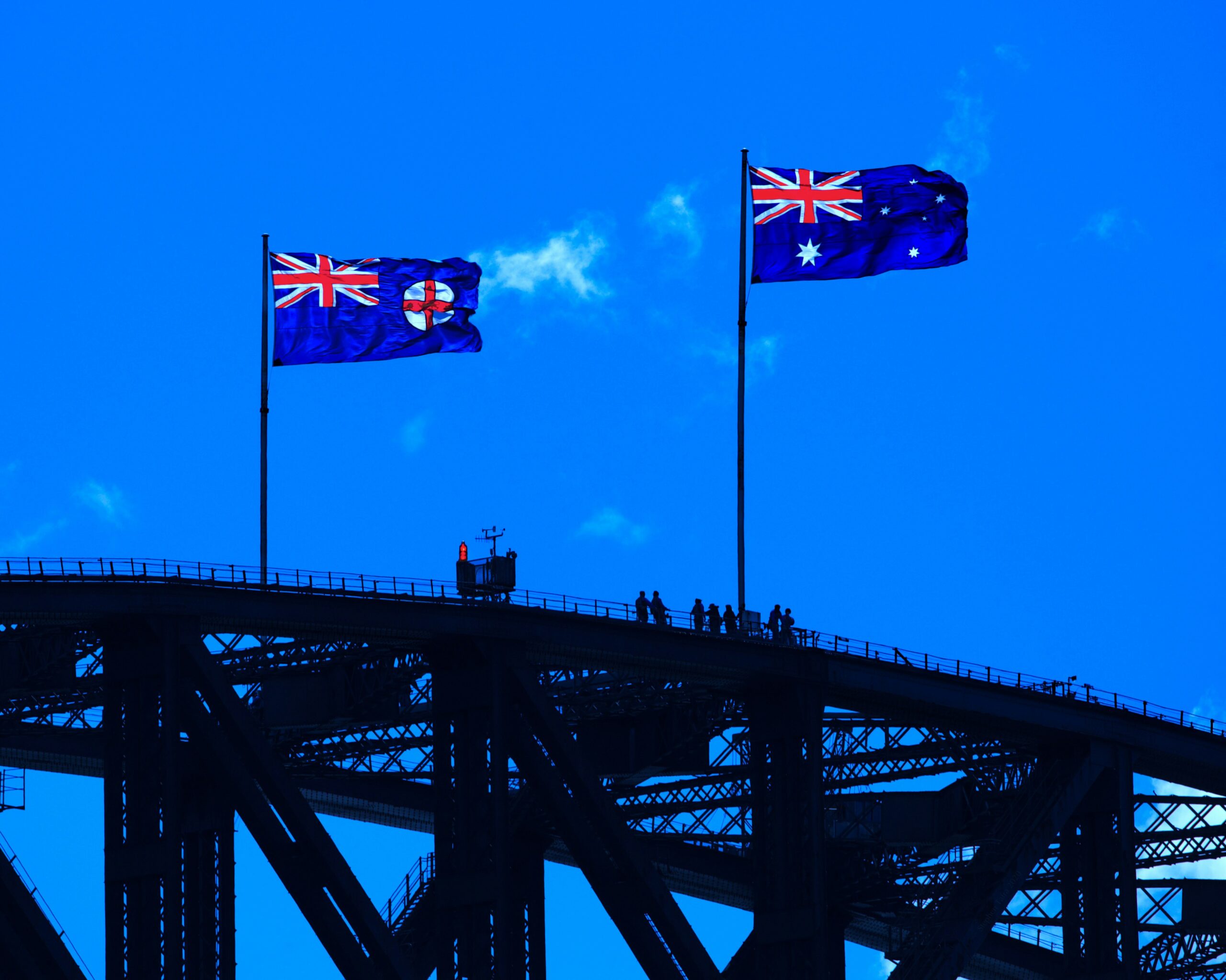 two flags on top of a bridge
