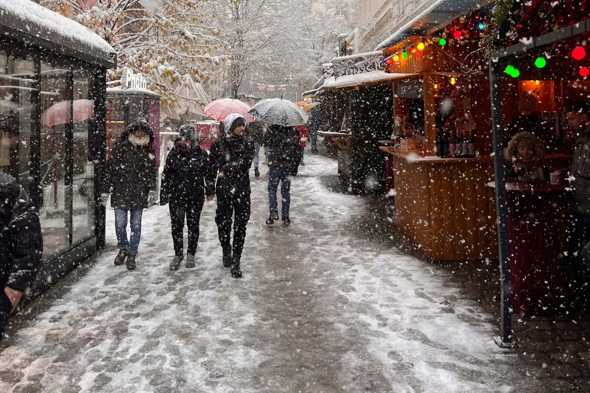 people walking with umbrellas in the snow